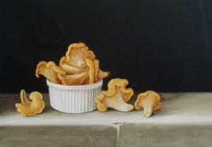Chanterelle mushrooms in a white ramekin with a black background